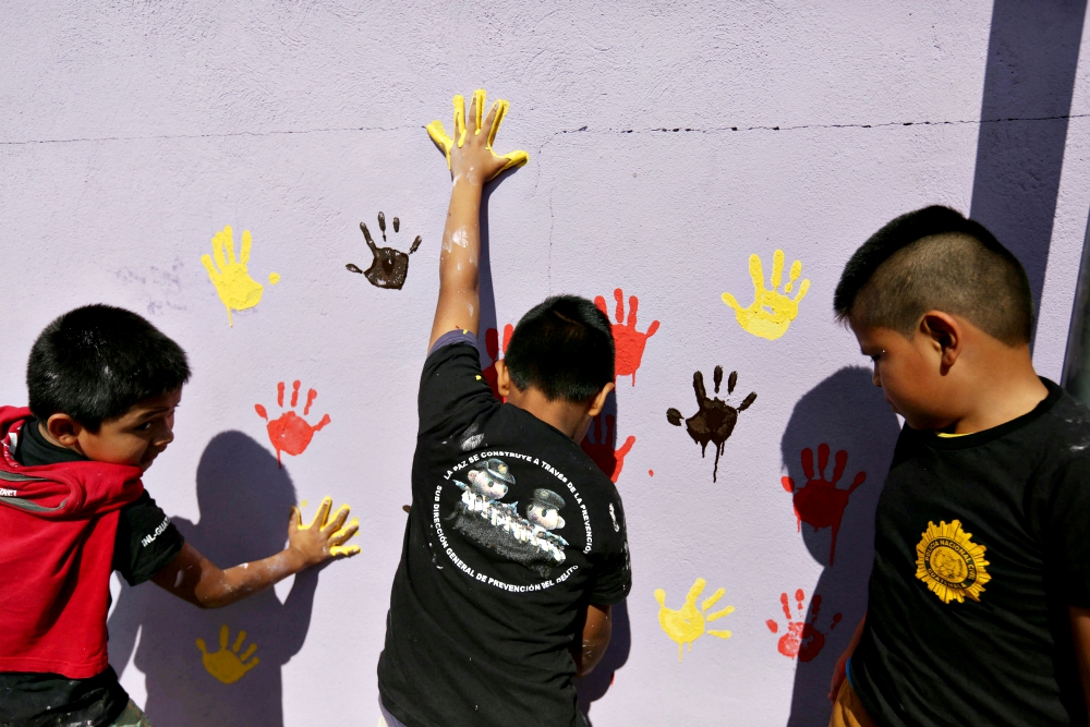 Children paint a wall with their handprints in early January 2017 as part of a project to recover walls painted with gang graffiti in Villa Nueva, Guatemala. (CNS/EPA/Esteban Biba)