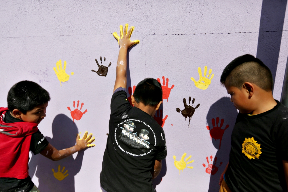 Children paint a wall with their handprints in early January 2017 as part of a project to recover walls painted with gang graffiti in Villa Nueva, Guatemala. (CNS/EPA/Esteban Biba) Children paint a wall with their handprints in early January 2017 as part of a project to recover walls painted with gang graffiti in Villa Nueva, Guatemala. (CNS/EPA/Esteban Biba)