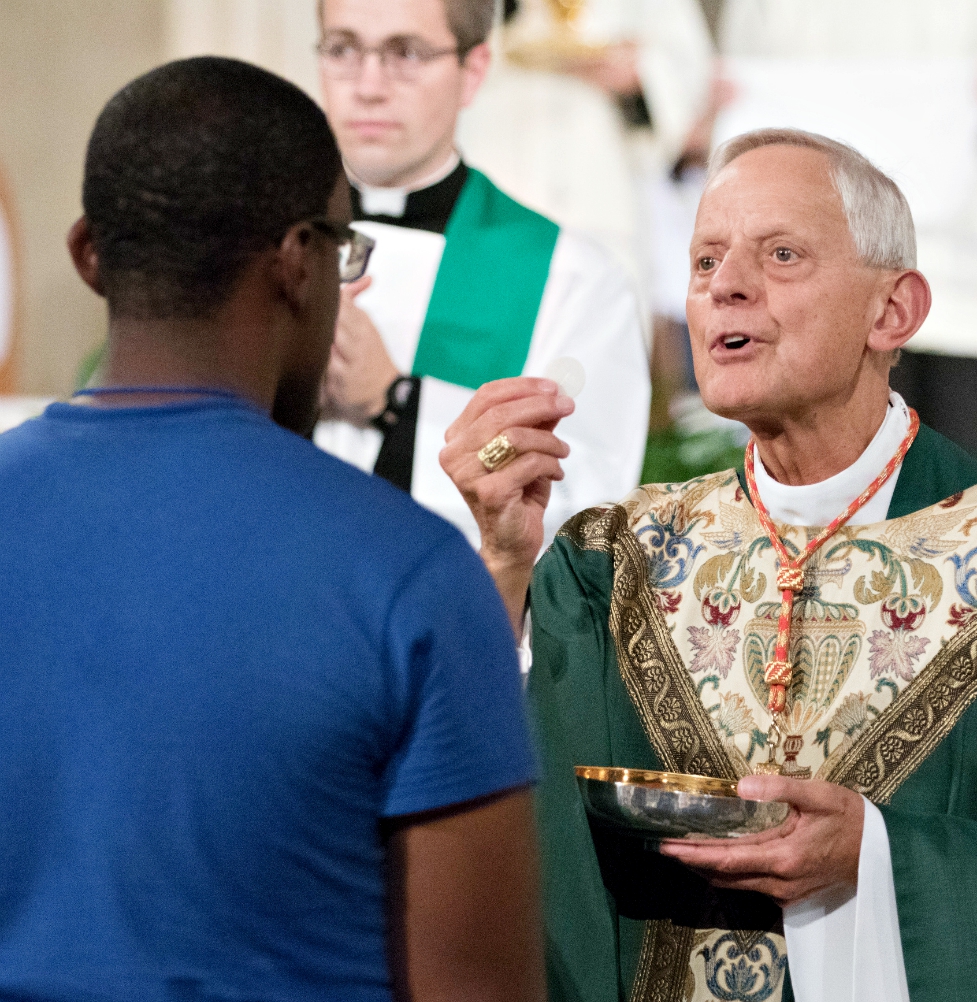 Cardinal Donald Wuerl distributes Communion to a World Youth Day Unite participant at the Basilica of the National Shrine of the Immaculate Conception in Washington July 22. (CNS/Courtesy of Archdiocese of Washington/Daphne Stubbolo)