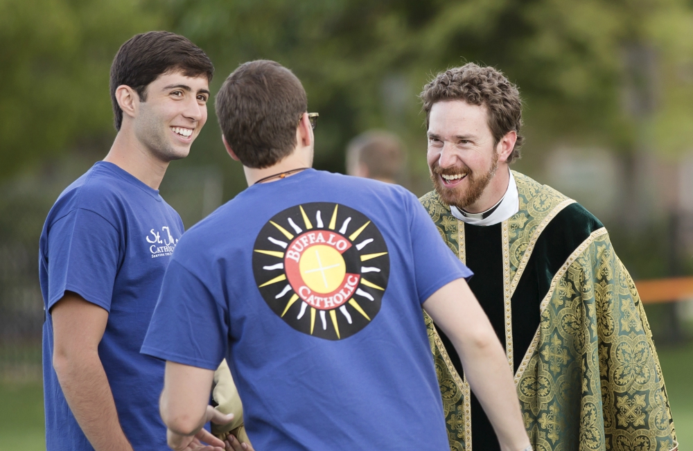 Fr. Peter Mussett, of St. Thomas Aquinas Catholic Center at the University of Colorado Boulder, chats with Fellowship of Catholic University Students missionaries on the campus in 2014. (CNS/Courtesy of FOCUS)
