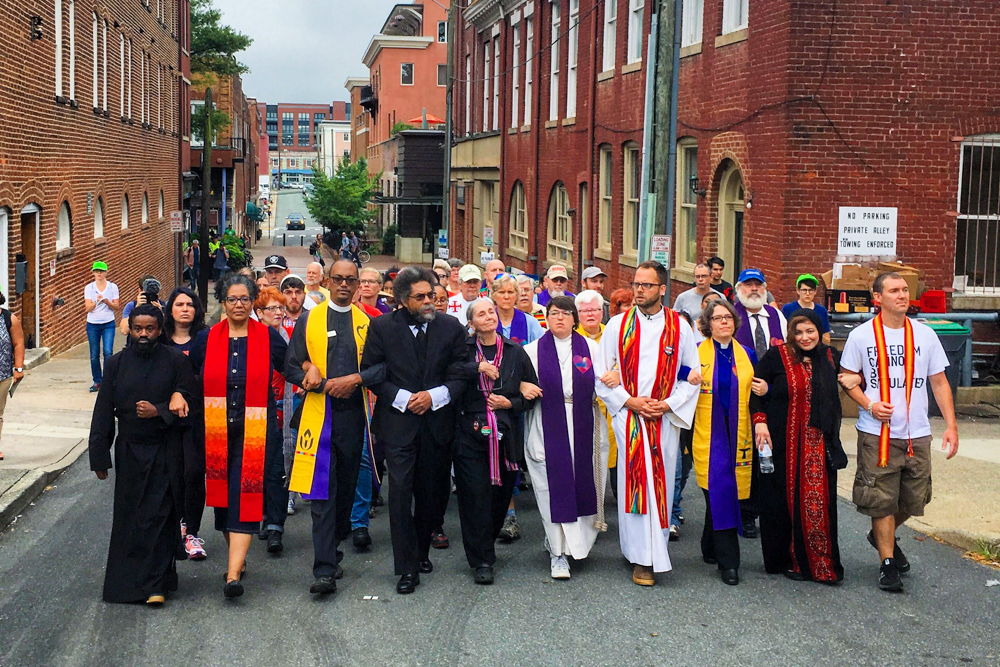 Eric Martin, first row far right, marches with clergy and faith leaders to counter protest the Unite the Right Rally in Charlottesville, Virginia, Aug. 12, 2018. (Photo by Jordy Yager)
