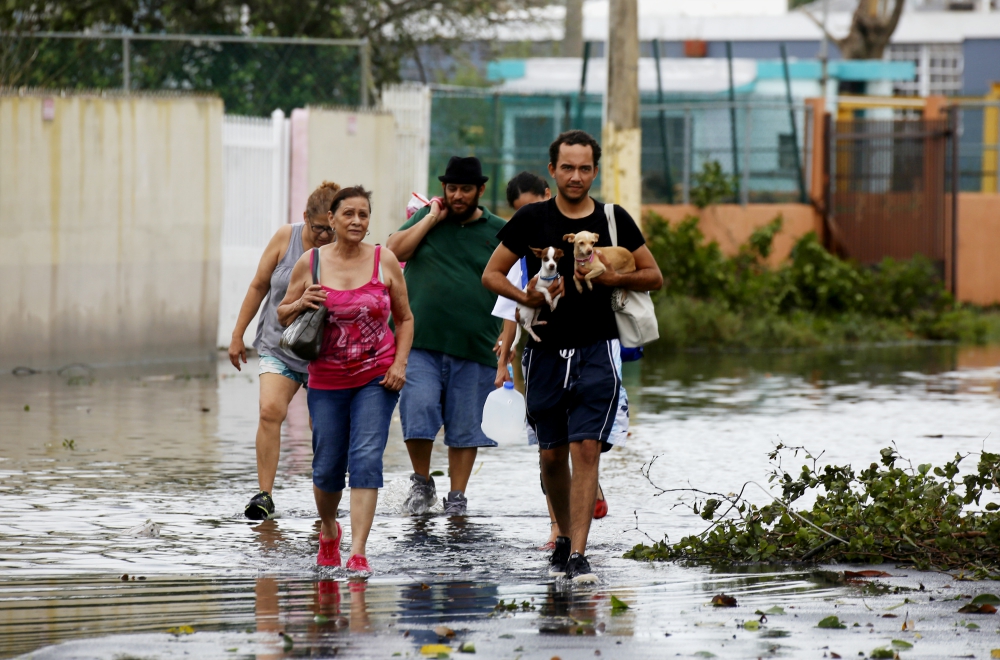 People walk in a flooded street Sept. 21 in Toa Baja, Puerto Rico, in the aftermath of Hurricane Maria. (CNS/EPA/Thais Llorca)
