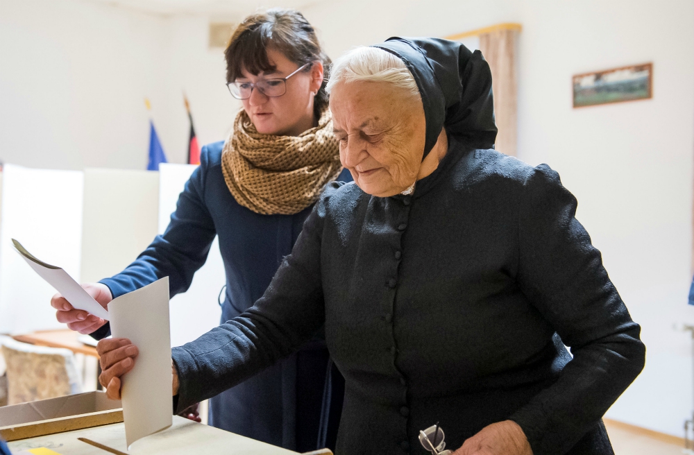 Women cast their votes Sept. 24 at a polling station in Crostwitz, Germany. (CNS/Reuters/Matthias Rietschel)