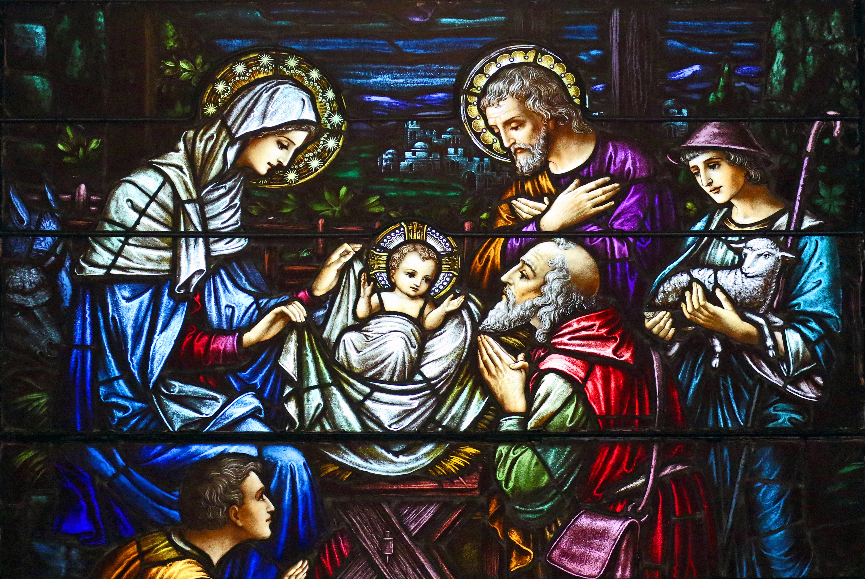 This stained-glass window at St. Aloysius Church in Great Neck, N.Y., depicts Jesus in a manger surrounded by Mary, Joseph and three shepherds. (CNS/Gregory A. Shemitz)