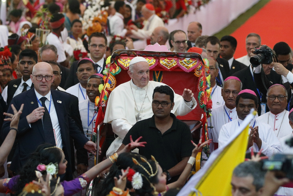 Pope Francis rides in a rickshaw as he arrives for an interreligious and ecumenical meeting for peace in the garden of the archbishop's residence in Dhaka, Bangladesh, Dec. 1. (CNS/Paul Haring)