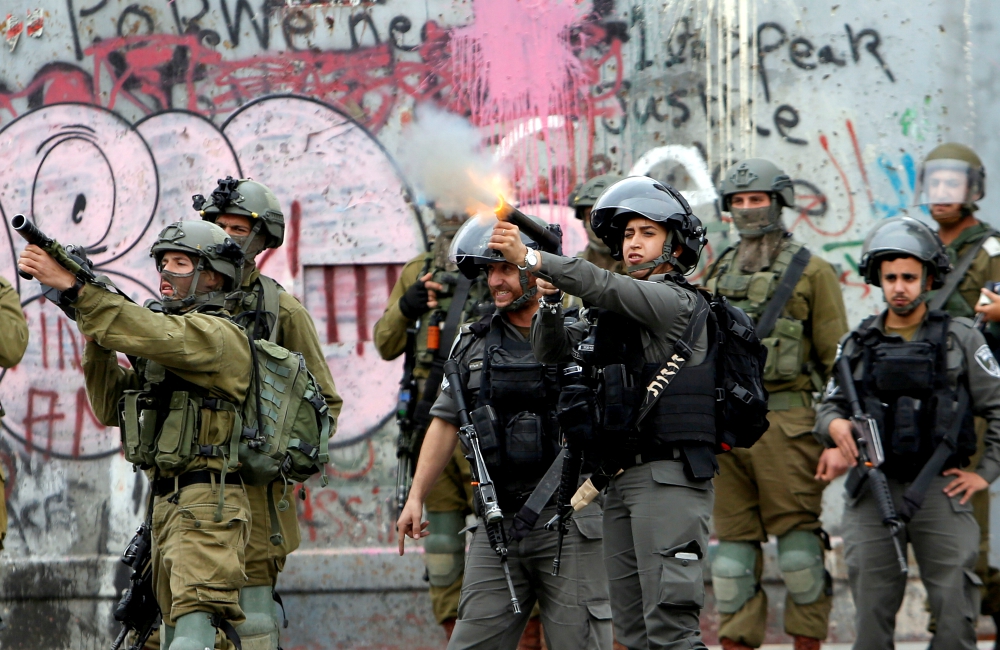 Israeli forces fire toward Palestinians near Ramallah, West Bank, during a Dec. 20 protest against U.S. President Donald Trump's decision to recognize Jerusalem as the capital of Israel. (CNS/Reuters/Mussa Qawasma) 