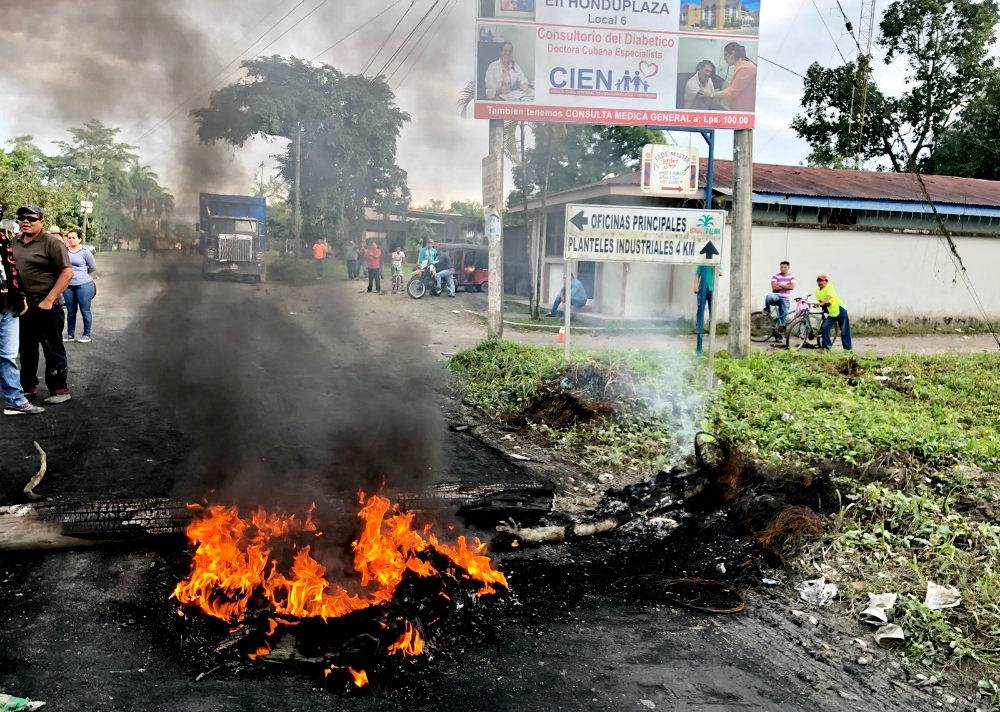 A road fire in in the Honduran community Aldea La 36 blocks workers from their jobs at the Hondupalma factory. (Tom Webb)