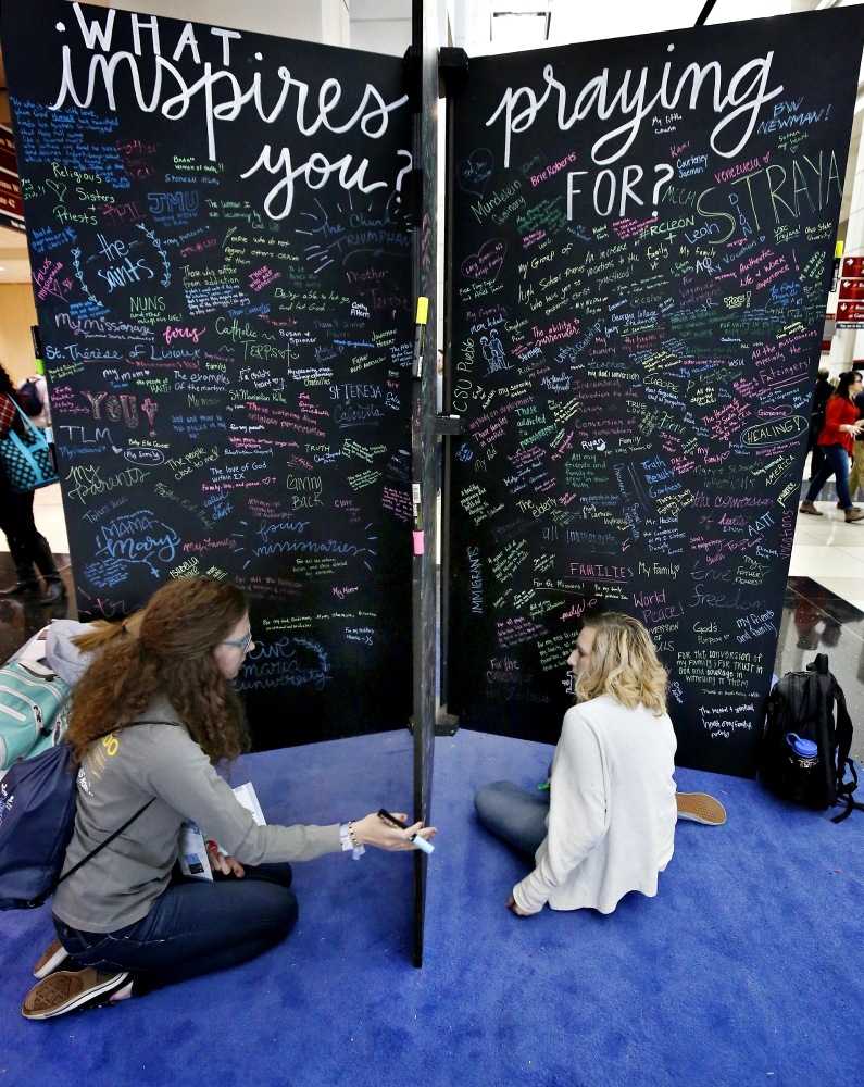 Katie Brown from the University of Toledo, Ohio, and Anna Davis from the University of Missouri Columbia, write their prayer intentions on a wall Jan. 3 during a conference sponsored by FOCUS in Chicago. (CNS/Chicago Catholic/Karen Callaway) Katie Brown from the University of Toledo, Ohio, and Anna Davis from the University of Missouri Columbia, write their prayer intentions on a wall Jan. 3 during a conference sponsored by FOCUS in Chicago. (CNS/Chicago Catholic/Karen Callaway)
