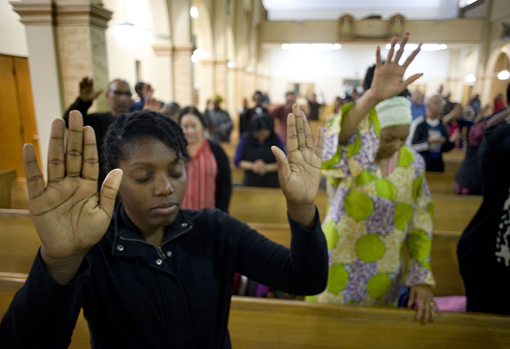 A young woman prays on the second evening of an African American Catholic revival celebration Feb. 6, 2018, at St. Rita's Catholic Church in San Diego. (CNS/David Maung)