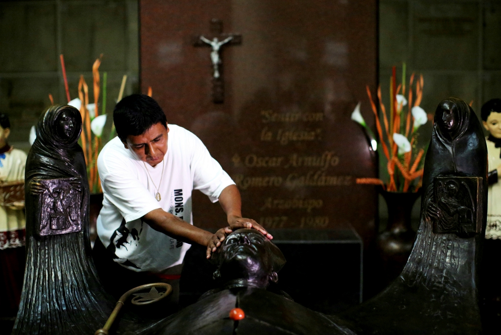 A man prays at the grave of Blessed Oscar Romero in 2017 at the Metropolitan Cathedral in San Salvador, El Salvador. (CNS/Reuters/Jose Cabezas)