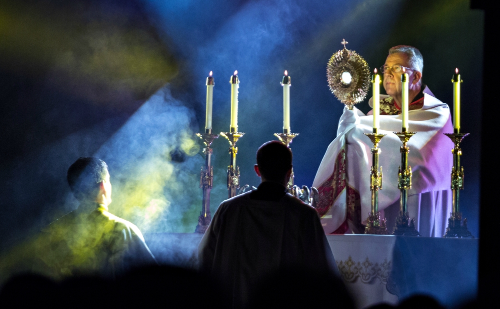 Capuchin Franciscan Fr. John Lager, national chaplain for FOCUS since 2013, holds the monstrance during adoration at the organization's SEEK 2015 gathering in Nashville, Tennessee. (CNS/Courtesy of FOCUS)