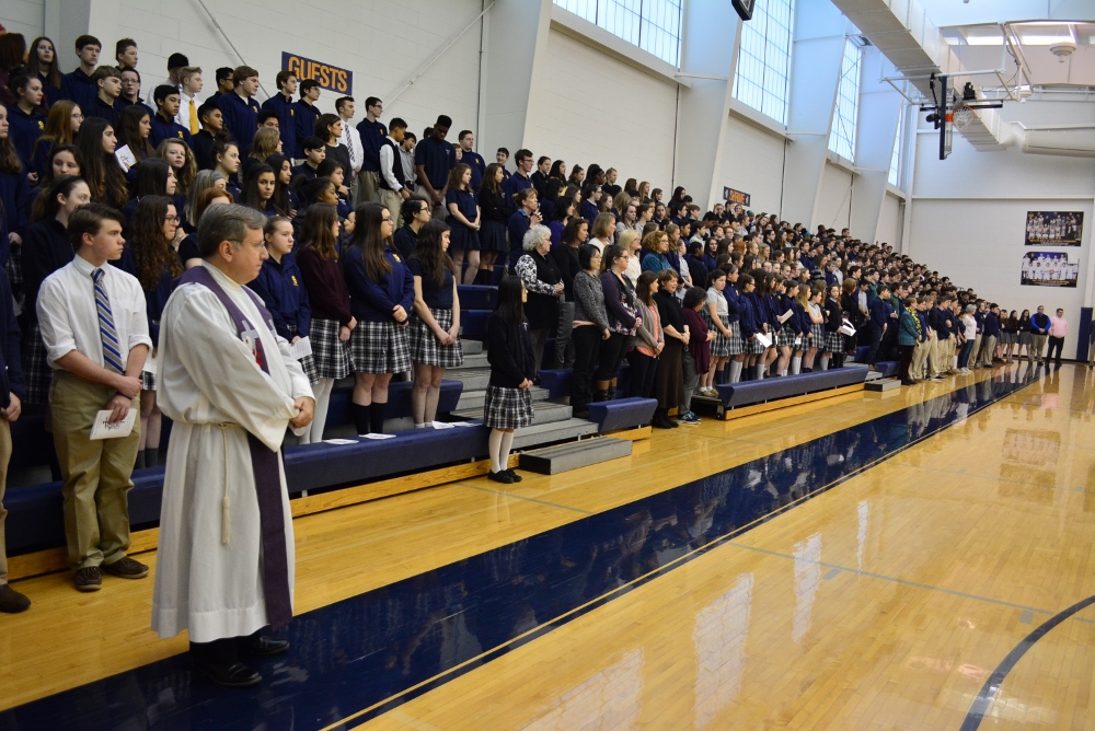 Msgr. Robert McClory listens with the student body of Shrine Catholic High School in Royal Oak, Mich., as the names of the Parkland, Florida, shooting victims are read during a schoolwide prayer vigil March 14. (CNS/Michigan Catholic/Mike Stechschulte)