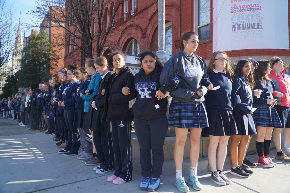 Presentation Academy students stand arm in arm on the sidewalk in downtown Louisville, Kentucky, after walking out of class at 10 a.m. March 14 to call attention to gun violence. (CNS/ The Record/Marnie McAllister)