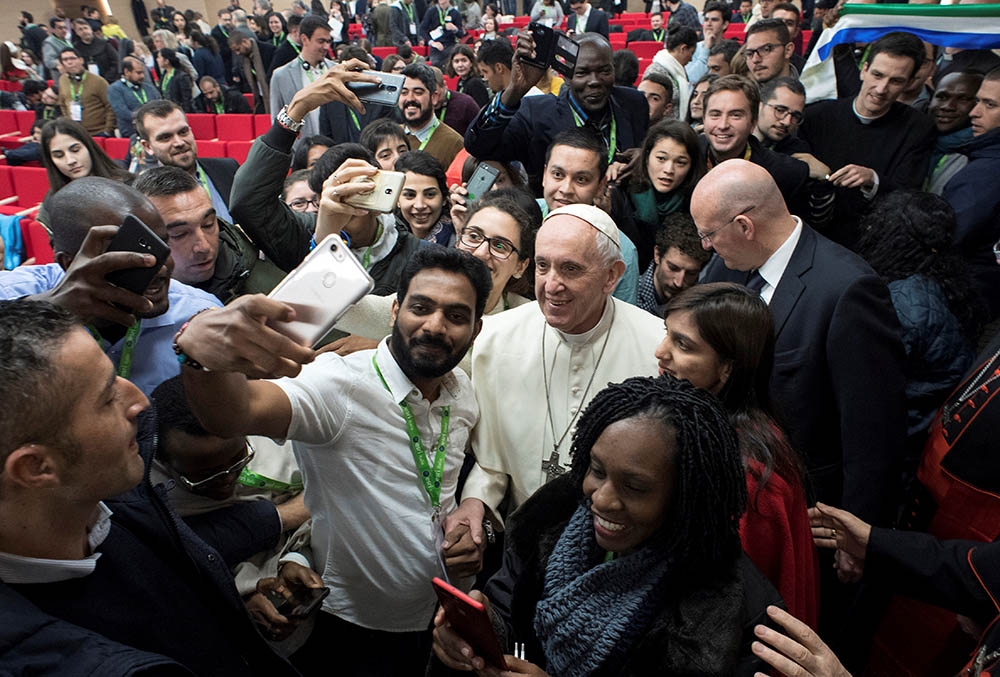 Pope Francis poses for a selfie during a pre-synod gathering of youth delegates at the Pontifical International Maria Mater Ecclesiae College in Rome March 19, 2018. The meeting was in preparation for the Synod of Bishops on young people in October 2018.