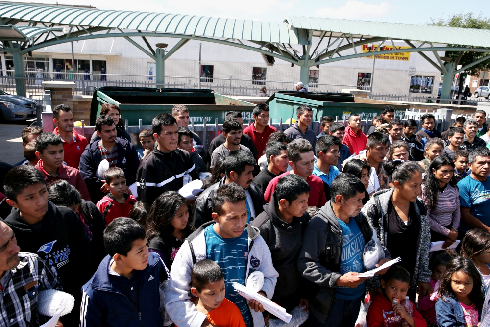 Immigrants just released from detention via a U.S. immigration policy known as "catch and release" stand at a bus station April 11 before being taken to the Catholic Charities relief center in McAllen, Texas. (CNS/Reuters/Loren Elliott)