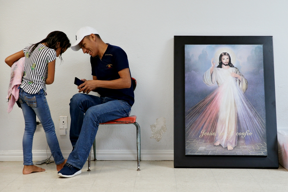 A Guatemalan immigrant and his daughter, recently released from detention through the U.S. immigration policy called "catch and release," talk with each other April 14 at the Catholic Charities relief center in McAllen, Texas. (CNS/Reuters/Loren Elliott) A Guatemalan immigrant and his daughter, recently released from detention through the U.S. immigration policy called "catch and release," talk with each other April 14 at the Catholic Charities relief center in McAllen, Texas. (CNS/Reuters/Loren Elliott)
