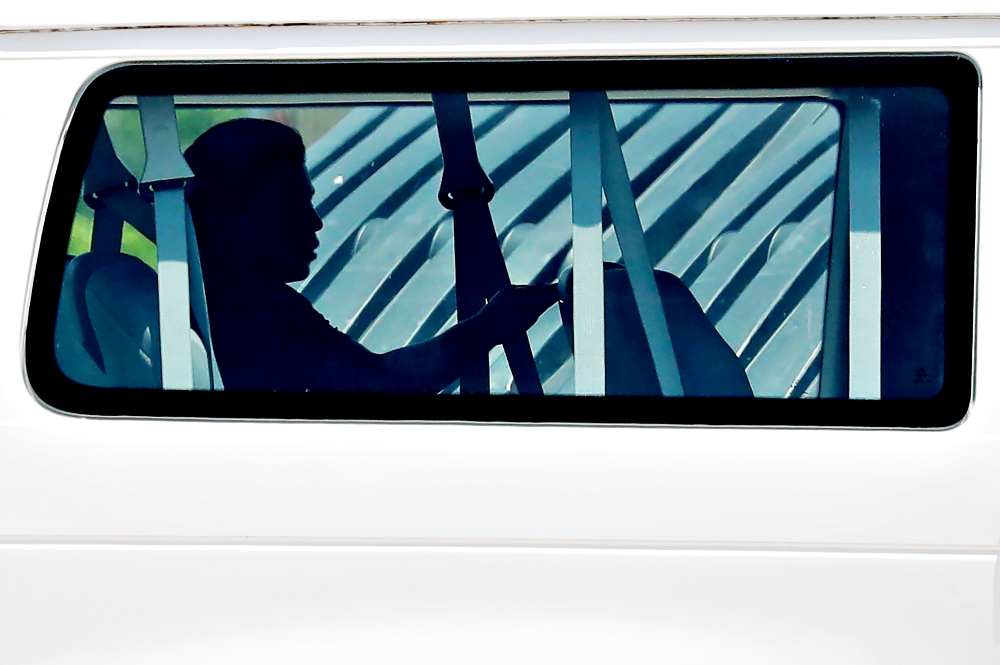 A minor sits in the back of a van July 11 as he is transported into Casa Esperanza, a federally contracted shelter in Brownsville, Texas. (CNS/Reuters/Carlos Barria)