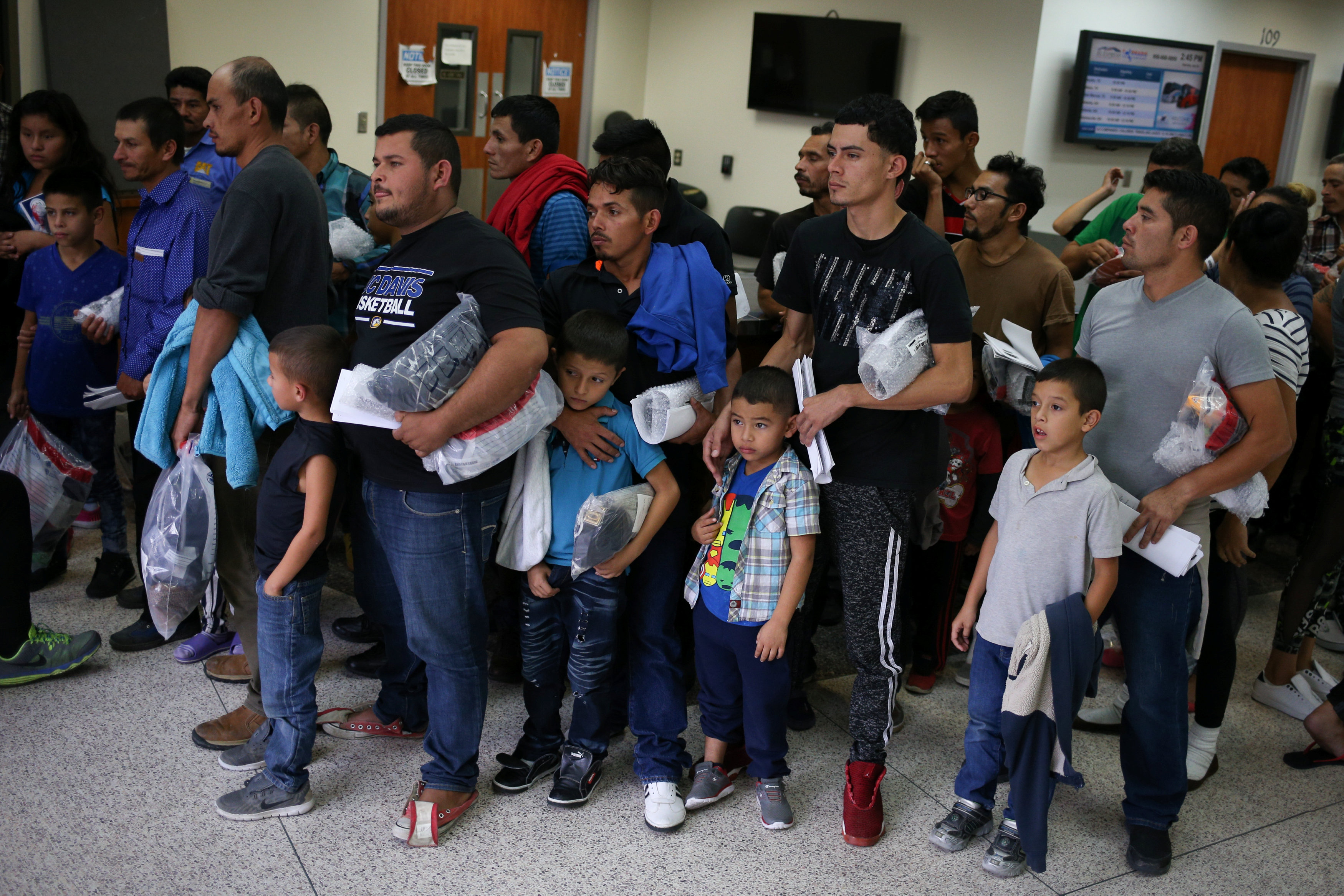 Immigrant families are released from detention July 27 at a bus depot in McAllen, Texas. (CNS/Loren Elliott, Reuters)