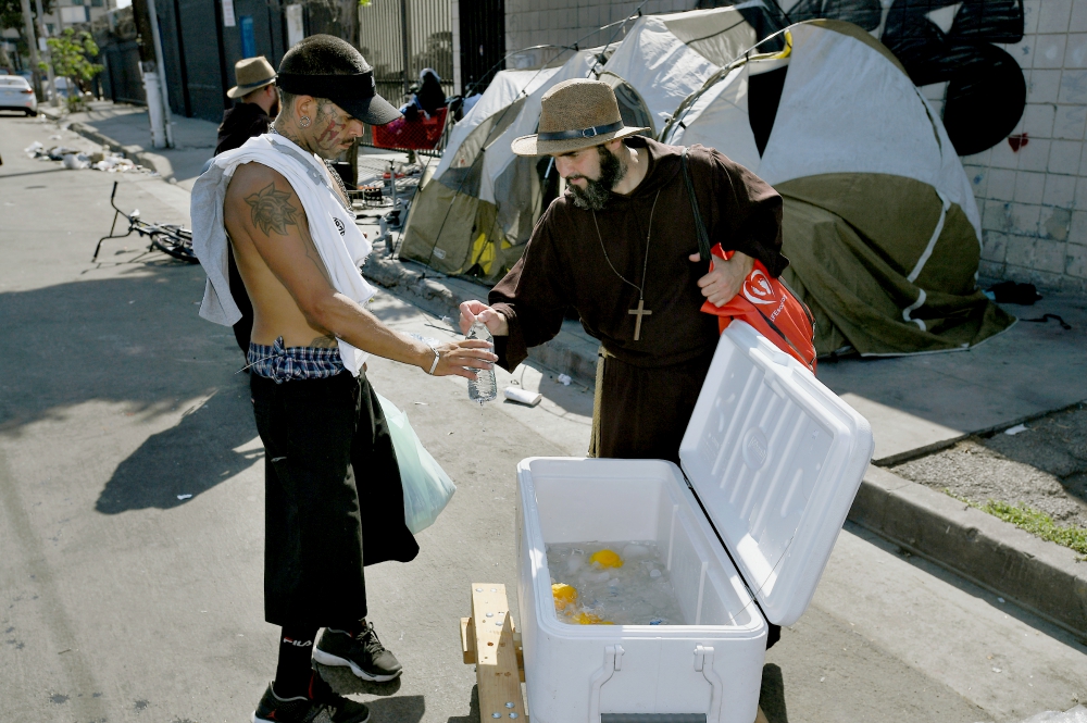Brazilian Friar Benjamin of the Most Holy Trinity gives water to a man on Skid Row in Los Angeles Aug. 18. (CNS/John McCoy via Angelus News)