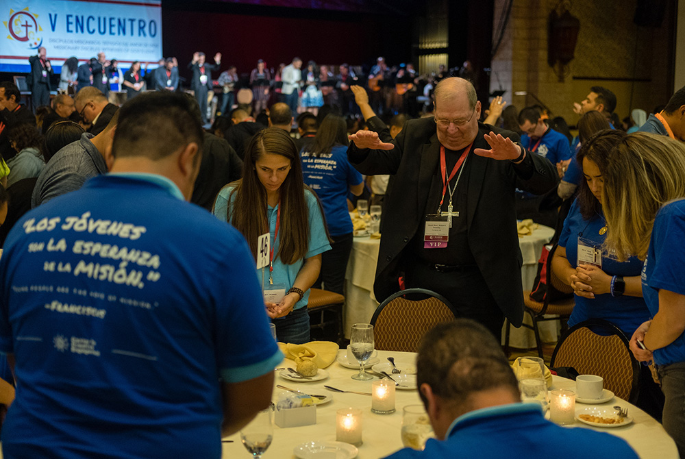 Bishop Robert Deeley of Portland, Maine, prays with young adults Sept. 21, 2018, during an evening encounter at the Fifth National Encuentro in Grapevine, Texas. (CNS/Texas Catholic Herald/James Ramos)