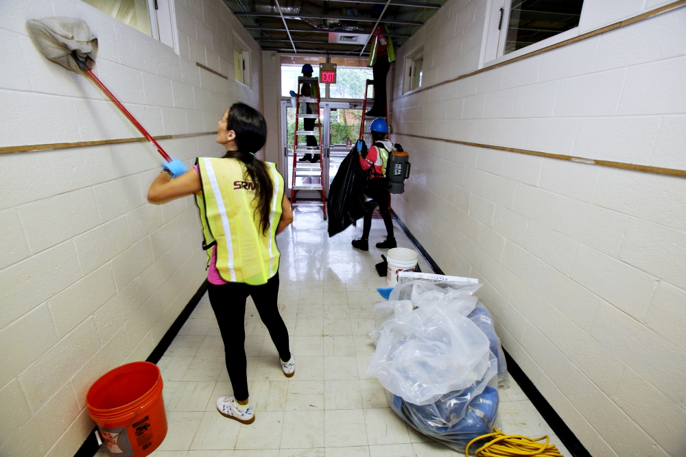 Restoration workers clean a hallway inside St. Mary School Sept. 28 in Wilmington, North Carolina, which sustained significant damage from Hurricane Florence. (CNS/Bob Roller)