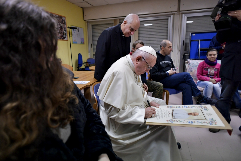 Pope Francis signs a papal blessing as he visits mentally disabled people at Il Ponte e l'Albero community on the outskirts of Rome Dec. 7, 2018. (CNS/Vatican Media) 