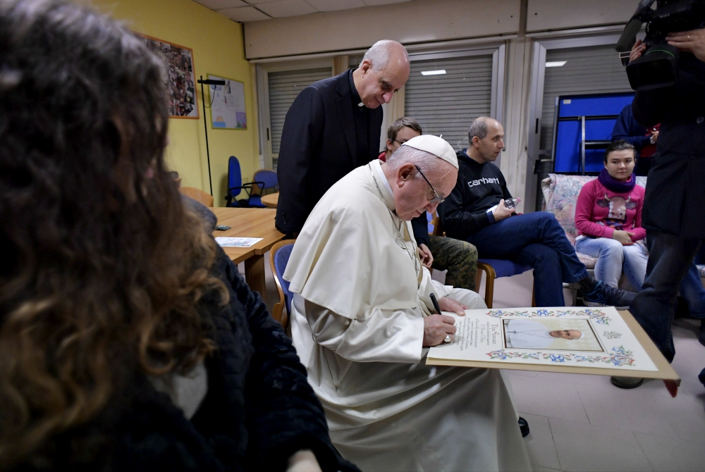 Pope Francis signs a papal blessing as he visits mentally disabled people at Il Ponte e l'Albero community on the outskirts of Rome Dec. 7, 2018. (CNS/Vatican Media) Pope Francis signs a papal blessing as he visits mentally disabled people at Il Ponte e l'Albero community on the outskirts of Rome Dec. 7, 2018. (CNS/Vatican Media)