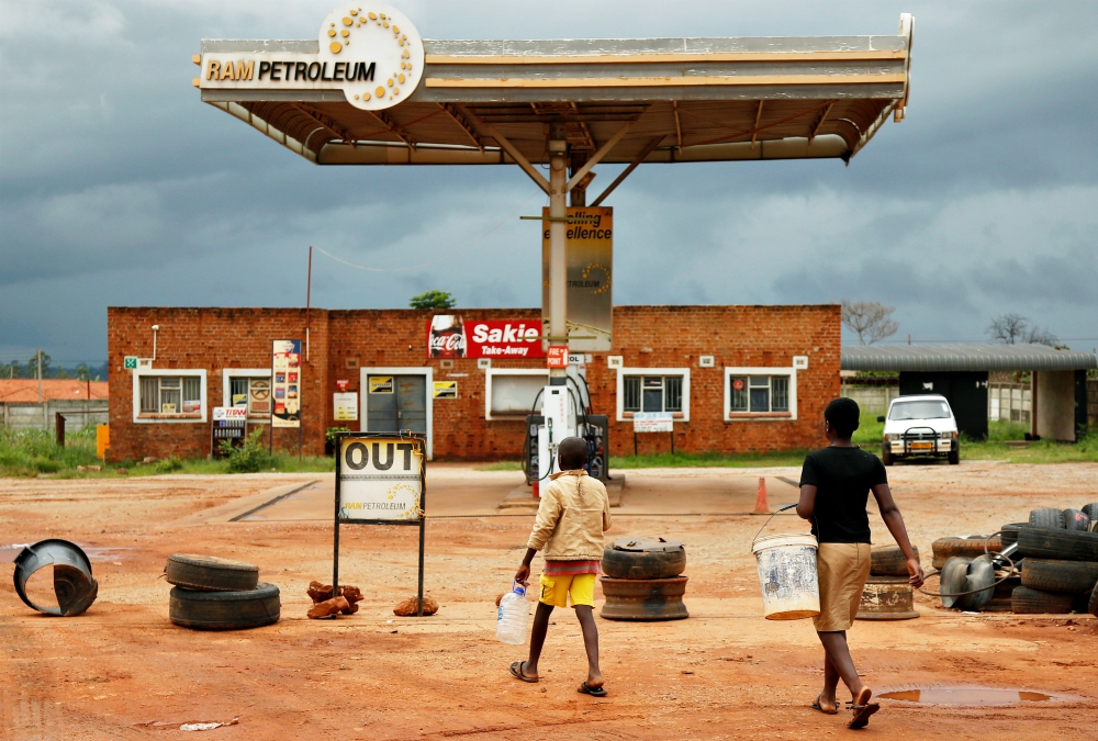 Young people walk past a gas station closed after protests over steep fuel price hikes Jan. 15, 2019, in Harare, Zimbabwe. (CNS/Reuters/Philimon Bulawayo)