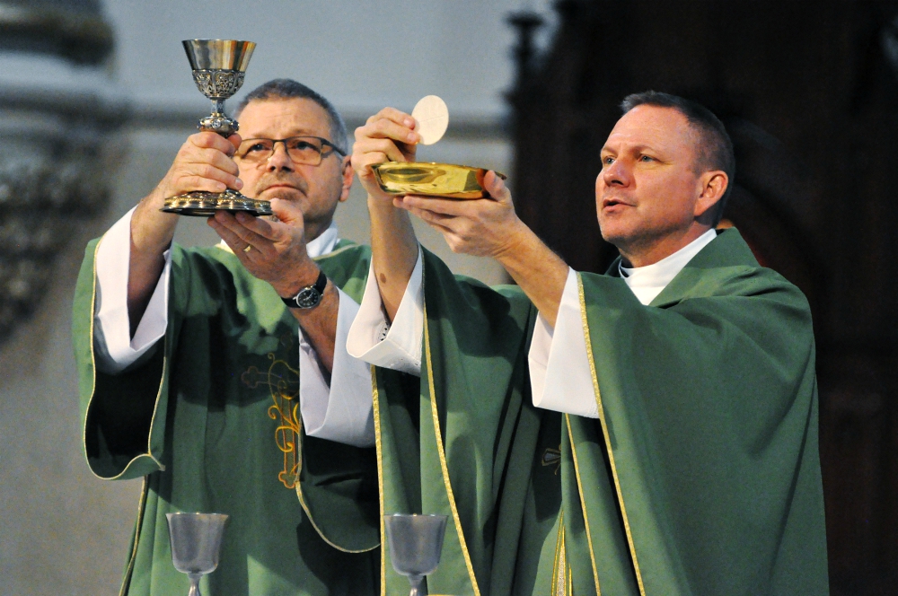 Deacon David Bartolowits, left, and Fr. Rick Nagel elevate the Eucharist during a Feb. 7 Mass at St. John the Evangelist Church in Indianapolis. (CNS/The Criterion/Sean Gallagher)