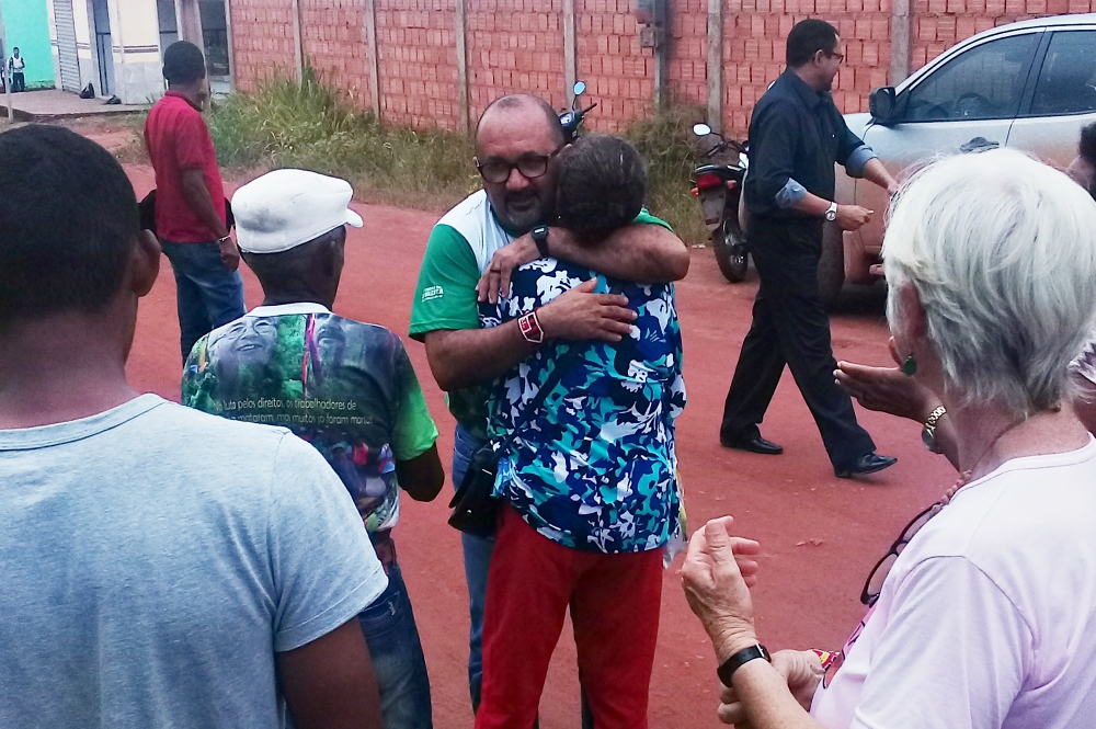 Fr. José Amaro hugs a supporter who was waiting in a nearby house with about 50 others after he finished testifying in court for four hours. (Carlos Tautz)