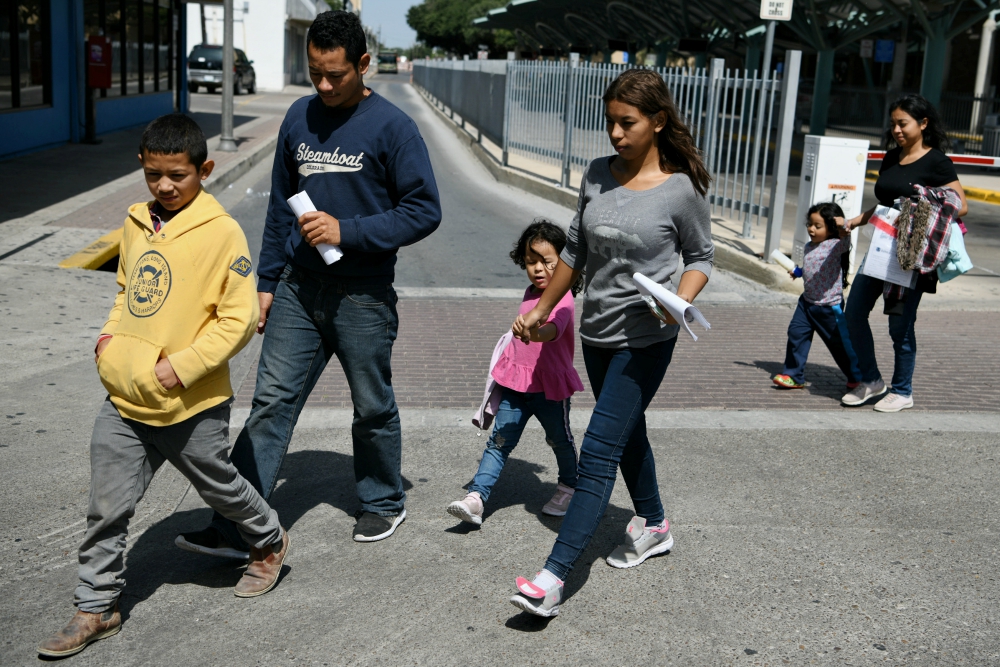 Migrant families seeking asylum walk from a bus depot to a Catholic Charities humanitarian respite center just after being released from federal detention in McAllen, Texas, July 31. (CNS/Reuters/Loren Elliott) Migrant families seeking asylum walk from a bus depot to a Catholic Charities humanitarian respite center just after being released from federal detention in McAllen, Texas, July 31. (CNS/Reuters/Loren Elliott)