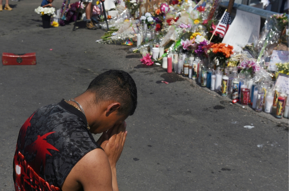 A man prays at a memorial Aug. 6, three days after a mass shooting at a Walmart store in El Paso, Texas. (CNS/Reuters/Callaghan O'Hare)