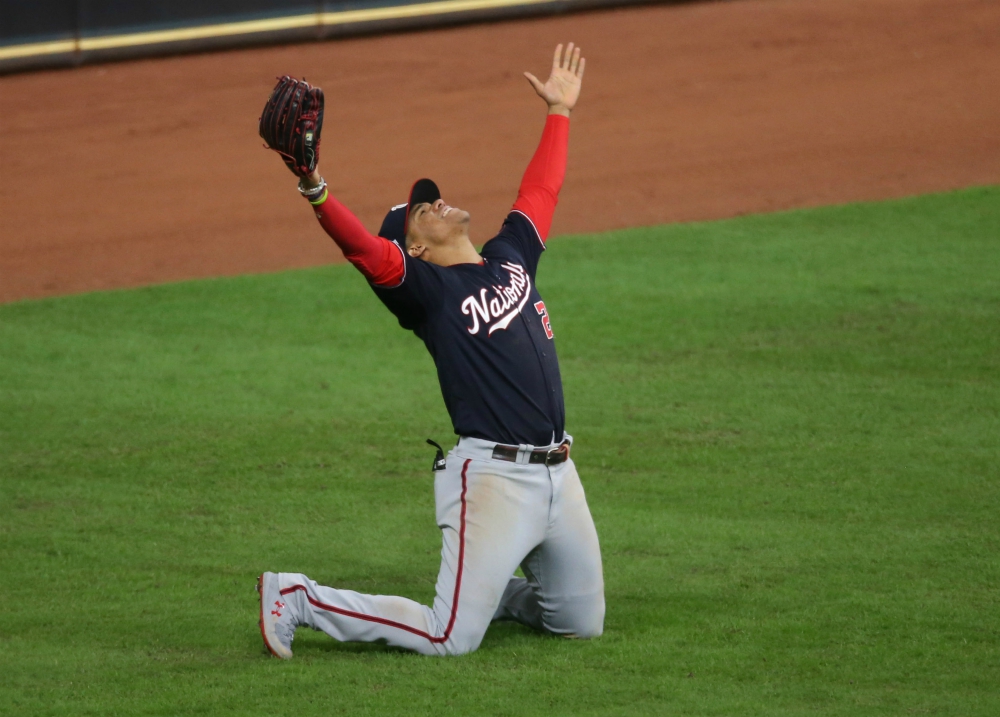 Washington Nationals' Juan Soto, front, stands in the dugout