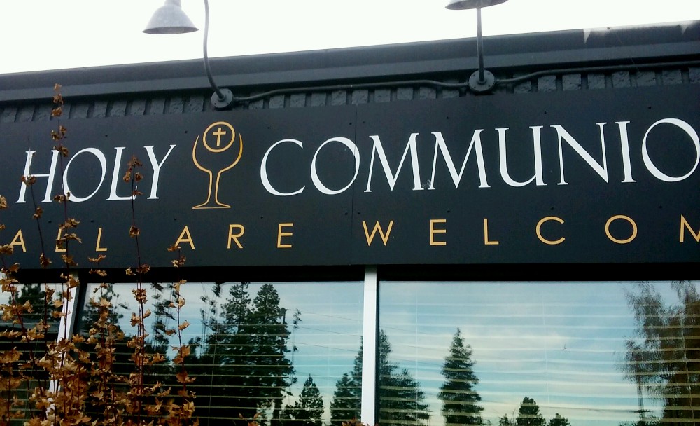 Attached to a strip mall storefront, a sign proclaims "All Are Welcome" at Holy Communion Church in Bend, Oregon. (NCR photo/Peter Feuerherd) Attached to a strip mall storefront, a sign proclaims "All Are Welcome" at Holy Communion Church in Bend, Oregon. (NCR photo/Peter Feuerherd)