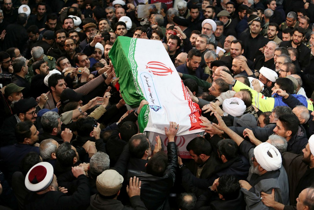 Mourners touch the casket of Iranian Maj. Gen. Qassem Soleimani during his funeral procession in Tehran Jan. 6. The military leader was killed Jan. 3 in a U.S. drone airstrike at Baghdad International Airport. (CNS/Khamenei website handout via Reuters)