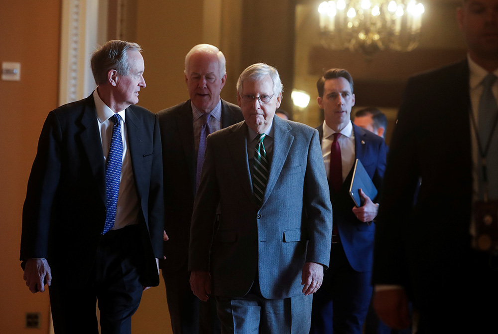 U.S. Senate Majority Leader Mitch McConnell, R-Ky., center, arrives with fellow Republican senators prior to the Senate receiving the House impeachment managers Jan. 16, and the procedural start of the impeachment trial of President Donald Trump at the U.