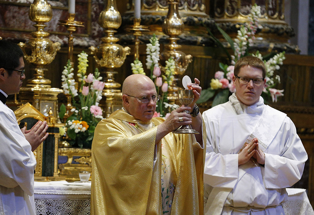 Bishop Michael Warfel of the Diocese of Great Falls-Billings, Montana, holds the Eucharist as bishops from Washington, Oregon, Idaho, Montana and Alaska concelebrate Mass at the Basilica of St. Mary Major Feb. 6, 2020, in Rome. (CNS/Paul Haring)