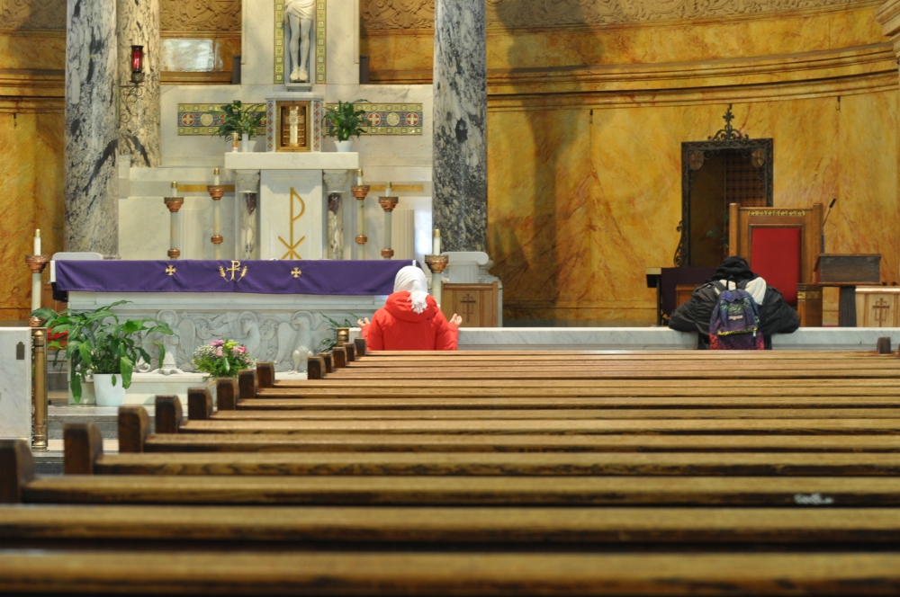 People pray in an empty St. Michael's Church in Brooklyn, New York, March 16, the first day that all Masses were suspended in the Brooklyn Diocese due to the coronavirus pandemic. (CNS/The Tablet/Ed Wilkinson) 