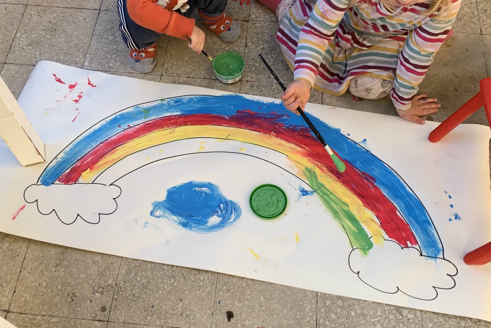 Joanna Kohorst's young children paint a rainbow on a large piece of paper during the lockdown that began March 10 in Rome because of the coronavirus pandemic. Someone also drew on a wall, so the markers are on a special lockdown within the lockdown. (CNS)