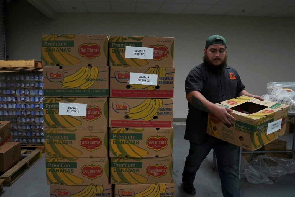 A man in Laredo, Texas, stacks relief boxes at the South Texas Food Bank March 20 during the coronavirus outbreak. (CNS/Reuters/Veronica G. Cardenas)