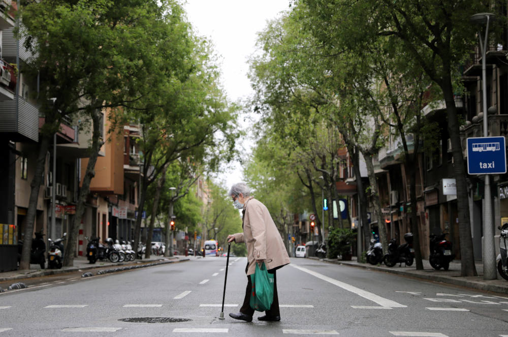 An elderly woman wears a protective face mask as she walks with shopping bags during the COVID-19 pandemic in Barcelona, Spain, April 1, 2020. (CNS photo/Nacho Doce, Reuters)