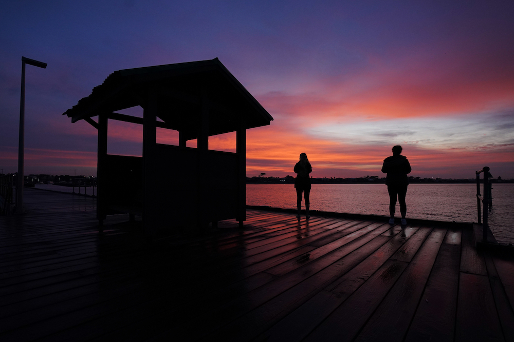 Local residents stop from their morning walk to take a photograph of the Mordialloc harbor at sunrise in Melbourne, Australia , April 3, 2020. (CNS/Michael Dodge, AAP Image via Reuters)