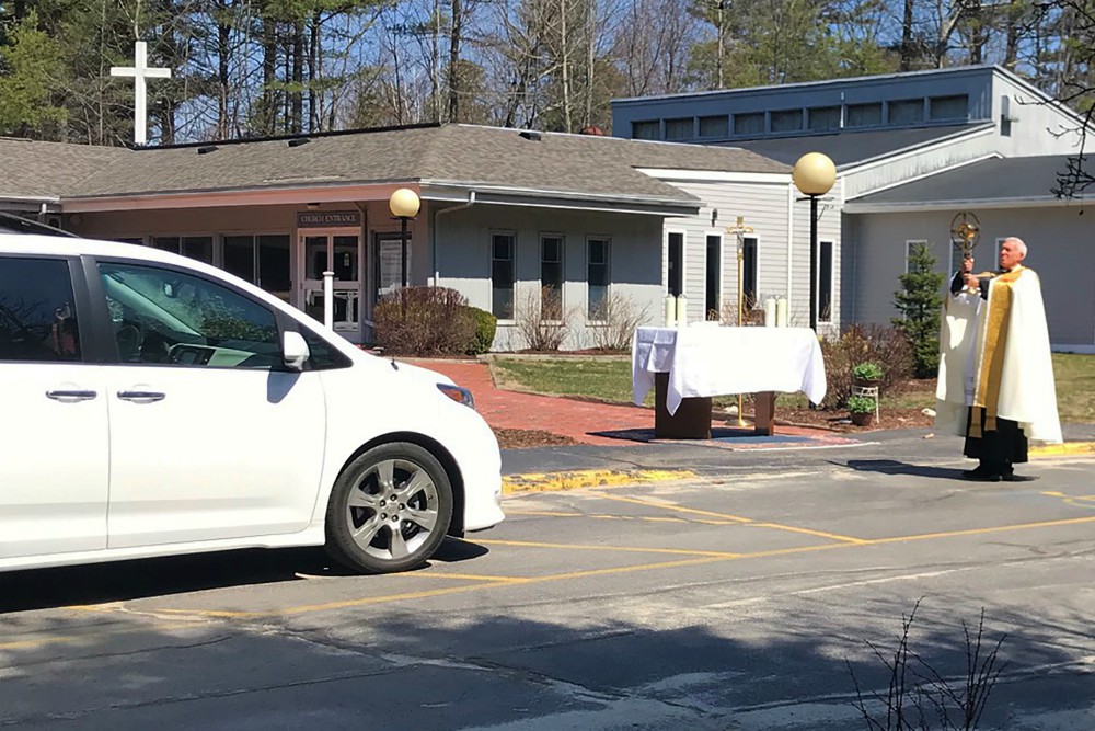Fr. Lou Phillips, pastor of Our Lady of Perpetual Help Parish in Windham, Maine, holds the Blessed Sacrament April 19 during a "drive-thru" Divine Mercy Sunday blessing in the church parking lot, amid the coronavirus pandemic. (CNS)