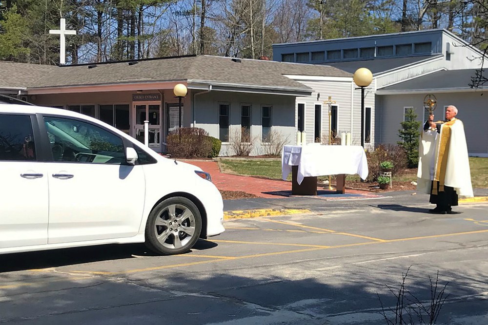 Fr. Lou Phillips, pastor of Our Lady of Perpetual Help Parish in Windham, Maine, holds the Blessed Sacrament April 19 during a "drive-thru" Divine Mercy Sunday blessing in the church parking lot, amid the coronavirus pandemic. (CNS) Fr. Lou Phillips, pastor of Our Lady of Perpetual Help Parish in Windham, Maine, holds the Blessed Sacrament April 19 during a "drive-thru" Divine Mercy Sunday blessing in the church parking lot, amid the coronavirus pandemic. (CNS)