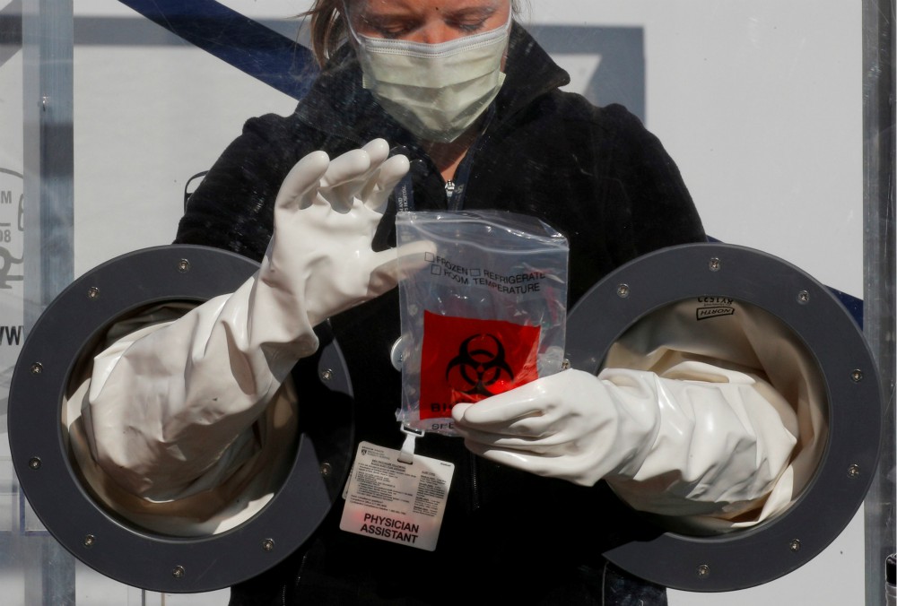 Physician Assistant Cori Kostick demonstrates the Brigham B-PROTECTED testing booth used to administer tests for COVID-19 at the Brigham and Women's Hospital community testing site in Boston May 5. (CNS/Reuters/Brian Snyder)