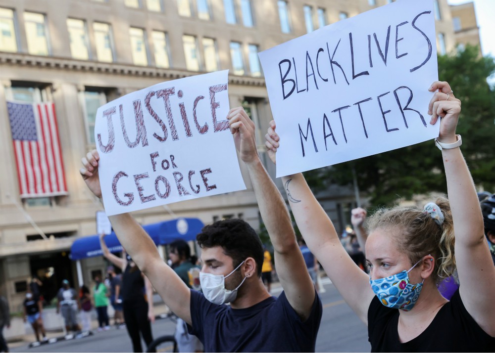 Demonstrators hold placards during a protest in Washington June 1. (CNS/Reuters/Jonathan Ernst)