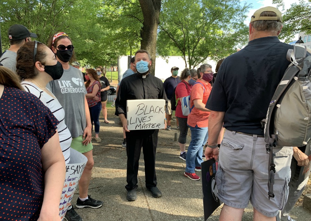 Fr. Joshua Laws, pastor of the Catholic Community of South Baltimore, holds a "Black Lives Matter" sign before the start of an interfaith prayer vigil in Baltimore June 3 to pray for justice and peace following the May 25 death of George Floyd. (CNS)