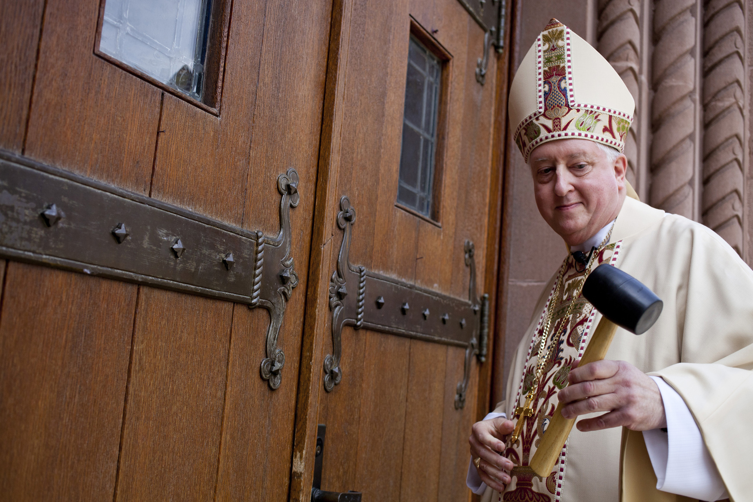 Bishop Mitchell Rozanski uses a mallet to knock three times on the doors of St. Michael's Cathedral in Springfield, Massachusetts, Aug. 12, 2014, before his installation as bishop of the diocese. (CNS/Catholic Review/Tom McCarthy Jr.)