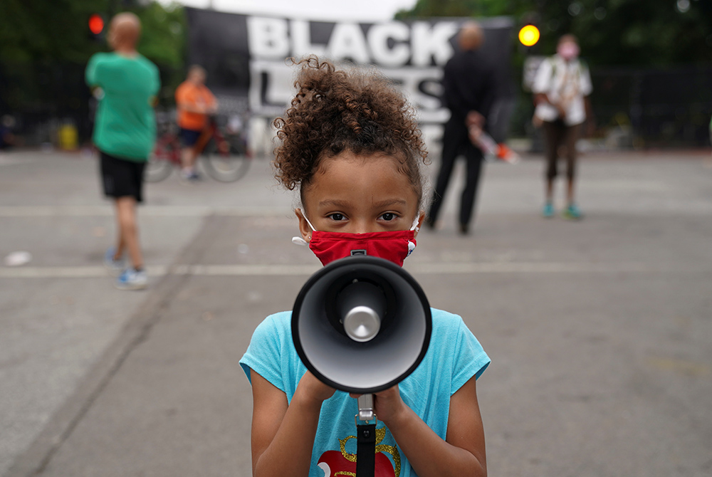 Mischa, 6, from Maryland, holds a bullhorn in front of a "Black Lives Matter" protest sign near the White House June 10, 2020, in Washington. (CNS/Kevin Lamarque, Reuters) Mischa, 6, from Maryland, holds a bullhorn in front of a "Black Lives Matter" protest sign near the White House June 10, 2020, in Washington. (CNS/Kevin Lamarque, Reuters)