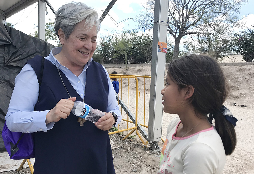 Sr. Norma Pimentel, director of Catholic Charities of the Rio Grande Valley in Texas, speaks with a young resident of a tent camp housing some 2,500 asylum-seekers in Matamoros, Mexico, Feb. 29, 2020. (CNS/David Agren)